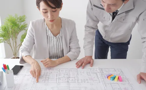 不動産会社で間取り図について会話する人たちの写真